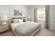 Serene bedroom with a striped bed, decorative pillows, and natural light streaming through the window at 744 Meadowbrook Ln, Summerville, SC 29486