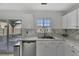 A well-lit kitchen featuring white cabinets, stainless steel appliances, and a view to the outside through sliding glass door at 7838 Long Shadow Ln, North Charleston, SC 29406