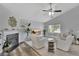 Bright, modern living room with a ceiling fan, plush white furniture, fireplace and ample natural light at 7838 Long Shadow Ln, North Charleston, SC 29406