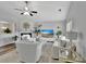 Bright, modern living room with plush white furniture, ceiling fan, and a decorative fireplace at 7838 Long Shadow Ln, North Charleston, SC 29406