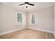 This bedroom features two windows, a ceiling fan and light-colored wood floors at 82 Ponsbury Rd, Mount Pleasant, SC 29464