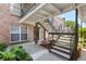 Courtyard exterior of a brick apartment building with stairs leading to the upper units and a small bench at 867 Colony Dr # F92, Charleston, SC 29407