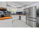 Well-lit kitchen with stainless steel appliances, white cabinets, wood countertops, and navy backsplash at 867 Colony Dr # F92, Charleston, SC 29407