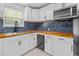 Bright kitchen features white cabinets, wood countertops, blue tile backsplash, and stainless steel appliances at 867 Colony Dr # F92, Charleston, SC 29407