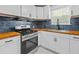 Modern kitchen featuring white cabinets, wood counters, stainless steel appliances, and stylish blue backsplash at 867 Colony Dr # F92, Charleston, SC 29407