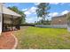 Expansive backyard with lush green grass, patio, and screened-in porch at 8987 Planters Row Ln, Summerville, SC 29485