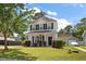 Charming two-story home with a well-manicured lawn, mature trees, and inviting front porch at 8987 Planters Row Ln, Summerville, SC 29485