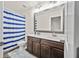 Bathroom with double vanity, soft rug, and striped shower curtain at 9009 Chato Ct, Summerville, SC 29483