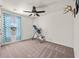 Bedroom featuring a ceiling fan, window with blue curtains, and exercise equipment at 9009 Chato Ct, Summerville, SC 29483
