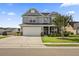 Charming two-story home with a well-manicured lawn, gray siding, and a two-car garage at 9009 Chato Ct, Summerville, SC 29483
