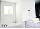 Bright bathroom featuring a soaking tub beneath a window and a vanity with modern fixtures at 9694 Roseberry St, Ladson, SC 29456