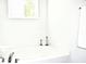 Bright bathroom featuring a soaking tub beneath a window and modern fixtures at 9694 Roseberry St, Ladson, SC 29456