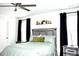 Inviting bedroom with ceiling fan, plush bedding, art, and bedside tables with modern lamps at 9694 Roseberry St, Ladson, SC 29456