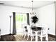Bright dining room features a modern chandelier, white chairs and a sliding glass door at 9694 Roseberry St, Ladson, SC 29456