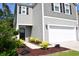 Charming two-story home featuring gray siding, black shutters, a two-car garage, and meticulous landscaping at 9694 Roseberry St, Ladson, SC 29456