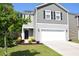 Charming two-story home featuring gray siding, black shutters, a two-car garage, and well-maintained landscaping at 9694 Roseberry St, Ladson, SC 29456