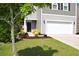 Charming home exterior with a well manicured lawn, lovely landscaping, and a two car garage at 9694 Roseberry St, Ladson, SC 29456