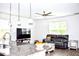 Open-concept living area featuring a large sofa, modern ceiling fan, and hardwood floors at 9694 Roseberry St, Ladson, SC 29456