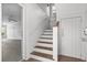 Bright entryway featuring wood stairs with white trim, light walls, and access to an adjacent room at 6 Kirkland Ln, Charleston, SC 29401