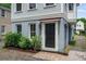 A welcoming home entrance features a dark front door, lush plants, and nicely painted grey base at 6 Kirkland Ln, Charleston, SC 29401