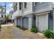 View of the side of the home with garage access, a light painted door, and a landscaped garden at 6 Kirkland Ln, Charleston, SC 29401