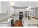 Bright kitchen boasts white cabinets, granite counters, stainless appliances, and a center island at 6 Kirkland Ln, Charleston, SC 29401