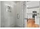 Glass enclosed shower showcasing the neutral tiling, door with stainless hardware and adjacent kitchen at 6 Kirkland Ln, Charleston, SC 29401