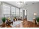 Cozy sitting room with hardwood floors, a modern chandelier, and natural light from the many windows at 6 Kirkland Ln, Charleston, SC 29401