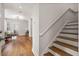 Hardwood staircase with access to the hardwood-floored living space with modern light fixture at 6 Kirkland Ln, Charleston, SC 29401