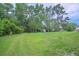 Large grassy backyard featuring a storage shed and satellite dishes at 1064 Blackbear Dr, Edisto Island, SC 29438