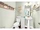 Charming bathroom with pedestal sink, coastal decor, and hardwood floors at 1064 Blackbear Dr, Edisto Island, SC 29438