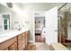 Bathroom with double vanity, wood cabinets, and doorway to bedroom at 1064 Blackbear Dr, Edisto Island, SC 29438