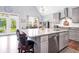 Bright kitchen with large island, gray cabinets, stainless appliances, and view to the outdoor space through french doors at 1064 Blackbear Dr, Edisto Island, SC 29438