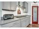 Close-up of a kitchen with modern gray cabinets, granite countertops, and stainless steel appliances at 1064 Blackbear Dr, Edisto Island, SC 29438