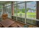 Screened porch providing panoramic views of a lush, green backyard and distant houses at 1064 Blackbear Dr, Edisto Island, SC 29438