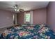 Cozy bedroom with floral bedding, ceiling fan, and a view through the window at 110 Cantering Hills Ln, Summerville, SC 29483