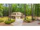 Exterior view of two-story home featuring brick accents, a two-car garage, and a tree-lined yard at 110 Cantering Hills Ln, Summerville, SC 29483