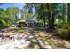 Expansive backyard with patio, lush greenery, and mature trees creates a serene retreat at 113 Overhill Dr, Walterboro, SC 29488