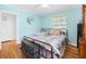 Bedroom features hardwood floors, light blue walls, and a black metal frame bed at 113 Overhill Dr, Walterboro, SC 29488