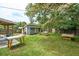 Lush backyard offers a peaceful retreat with mature trees, fire pit, and outbuilding at 1160 Landsdowne Dr, Charleston, SC 29412