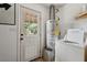Efficient laundry room features a modern washer, water heater, and an exterior door at 1160 Landsdowne Dr, Charleston, SC 29412