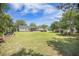 Spacious backyard with a well-manicured lawn, mature trees, patio seating, and charming details, creating an inviting outdoor space at 127 Travis Hill Rd, Moncks Corner, SC 29461