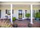 Inviting front porch with brick flooring, decorative plants, and seating area at 127 Travis Hill Rd, Moncks Corner, SC 29461
