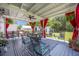 Open air patio offers comfortable seating with bright red curtains to offer shade from the sun at 127 Travis Hill Rd, Moncks Corner, SC 29461
