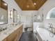 Beautiful bathroom featuring a wood ceiling, double vanity with marble counters, and a soaking tub at 1280 Waterfront Dr, Mount Pleasant, SC 29464
