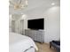 Spacious main bedroom with tray ceiling, chandelier, wood floors, dresser, and large television at 1280 Waterfront Dr, Mount Pleasant, SC 29464