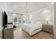 Bright main bedroom with tray ceiling, chandelier, wood floors, and windows with backyard views at 1280 Waterfront Dr, Mount Pleasant, SC 29464