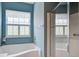 Bright bathroom with a white soaking tub, glass enclosed shower, and a shuttered window at 1335 Hopton Cir # 1335, Mount Pleasant, SC 29466
