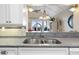 Close-up of a kitchen sink offering a view of the living area and a glimpse of the outdoor scenery at 1376 Pelican Watch Villas, Seabrook Island, SC 29455