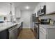 Well-appointed kitchen with white cabinets, stainless steel appliances, and hardwood floors at 1445 Downwood Pl, Charleston, SC 29412